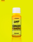 Slapp brand ginger turmeric wellness shot bottle on yellow background.